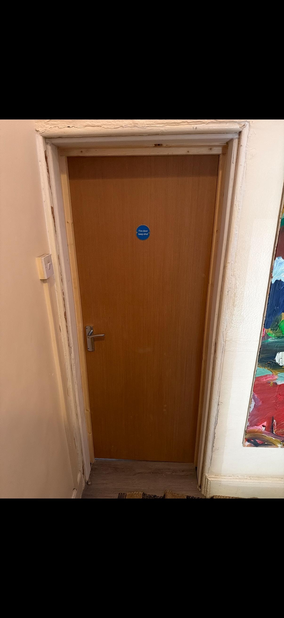Brown wooden fire door with blue sticker