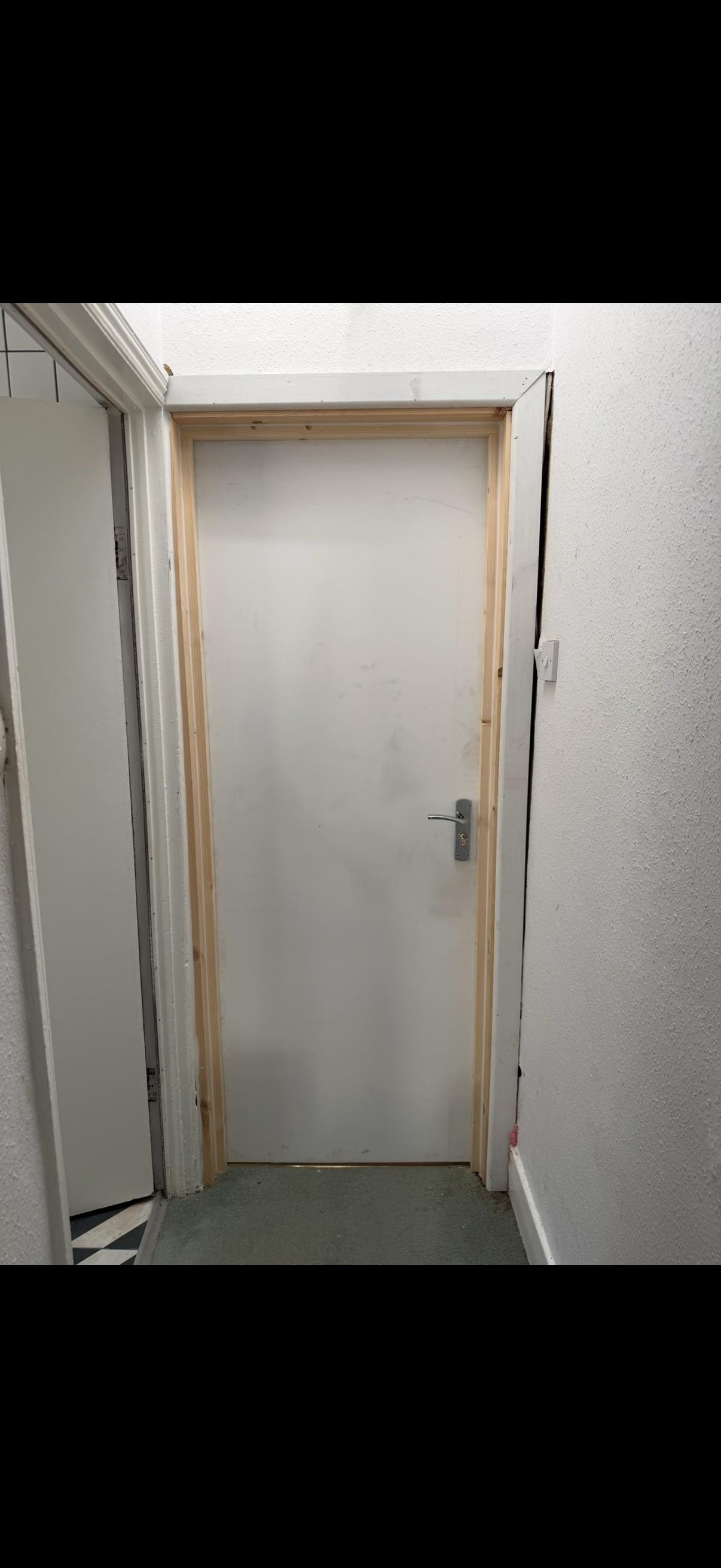 White fire door with wooden frame hallway