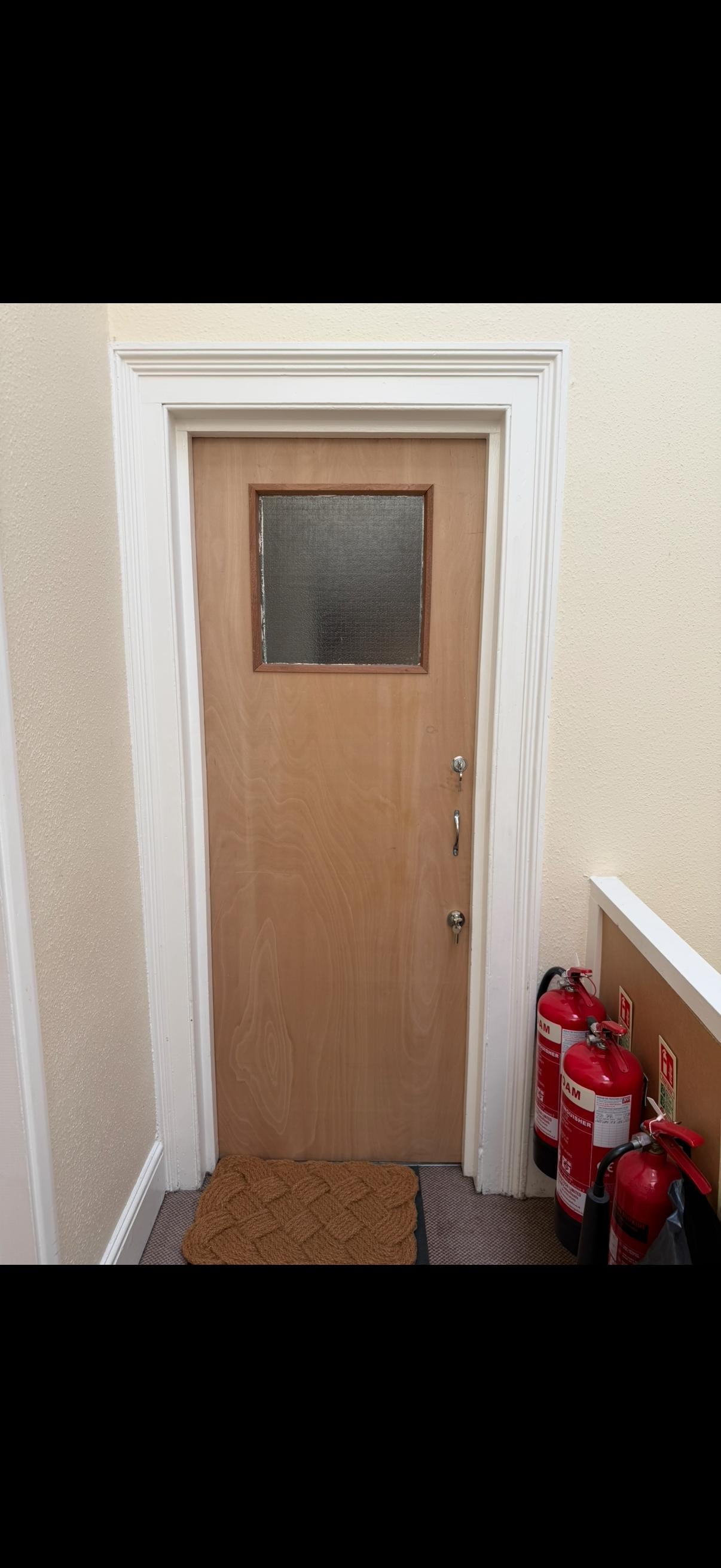 Wooden glazed fire door with window and fire extinguishers