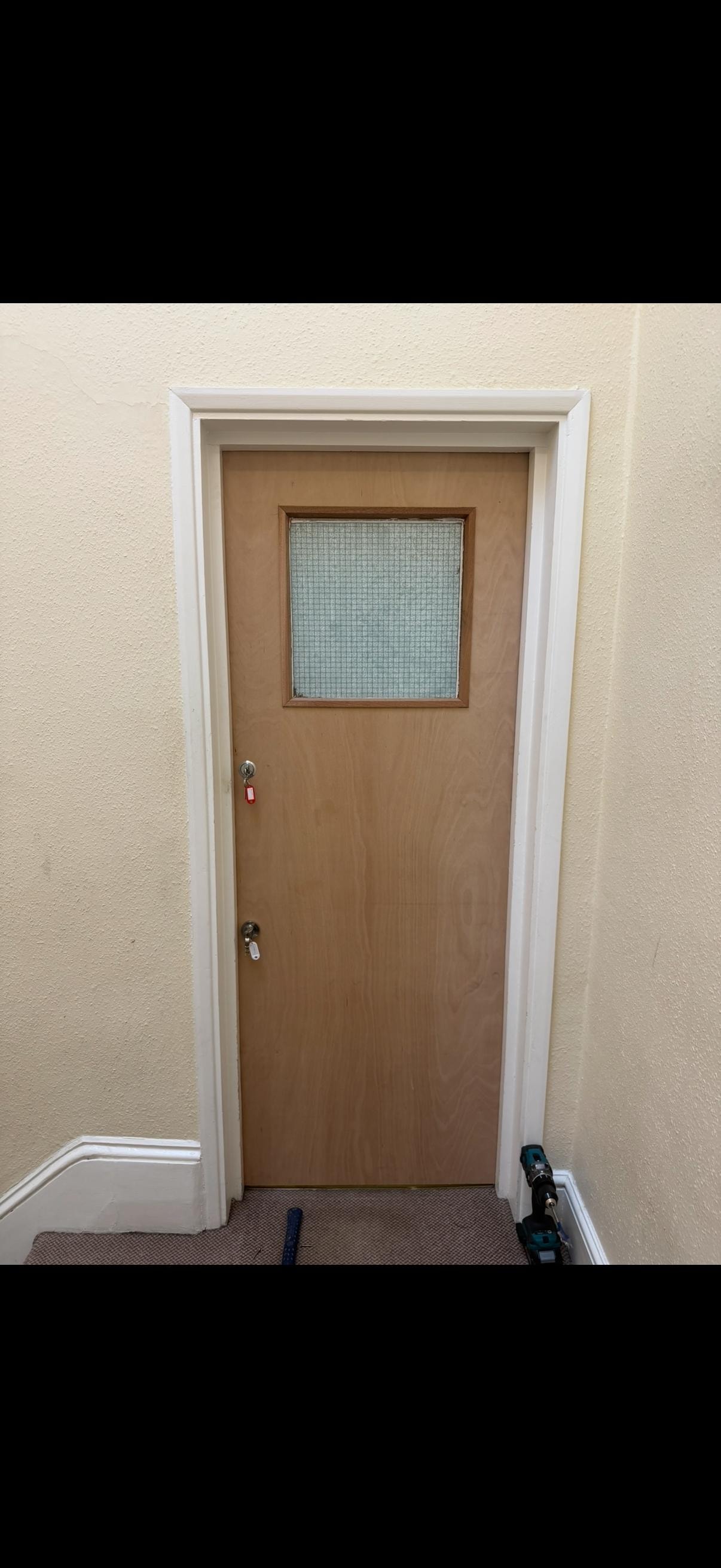 Wooden glazed fire door with window pane in hallway