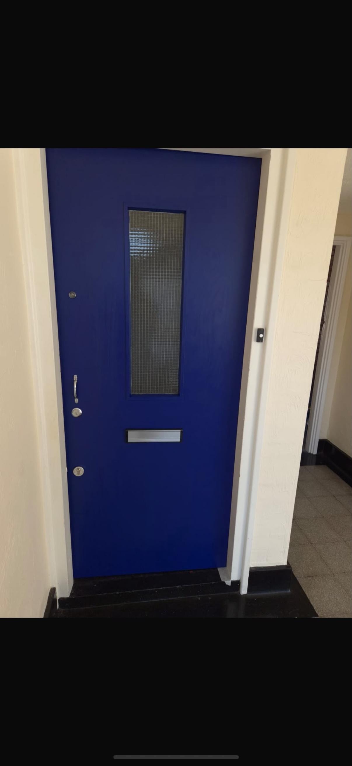 Bright blue fire door with glass panel