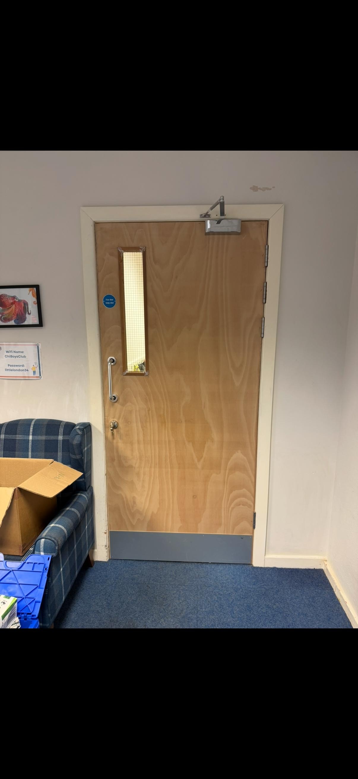 Wooden glazed fire door with window in office interior