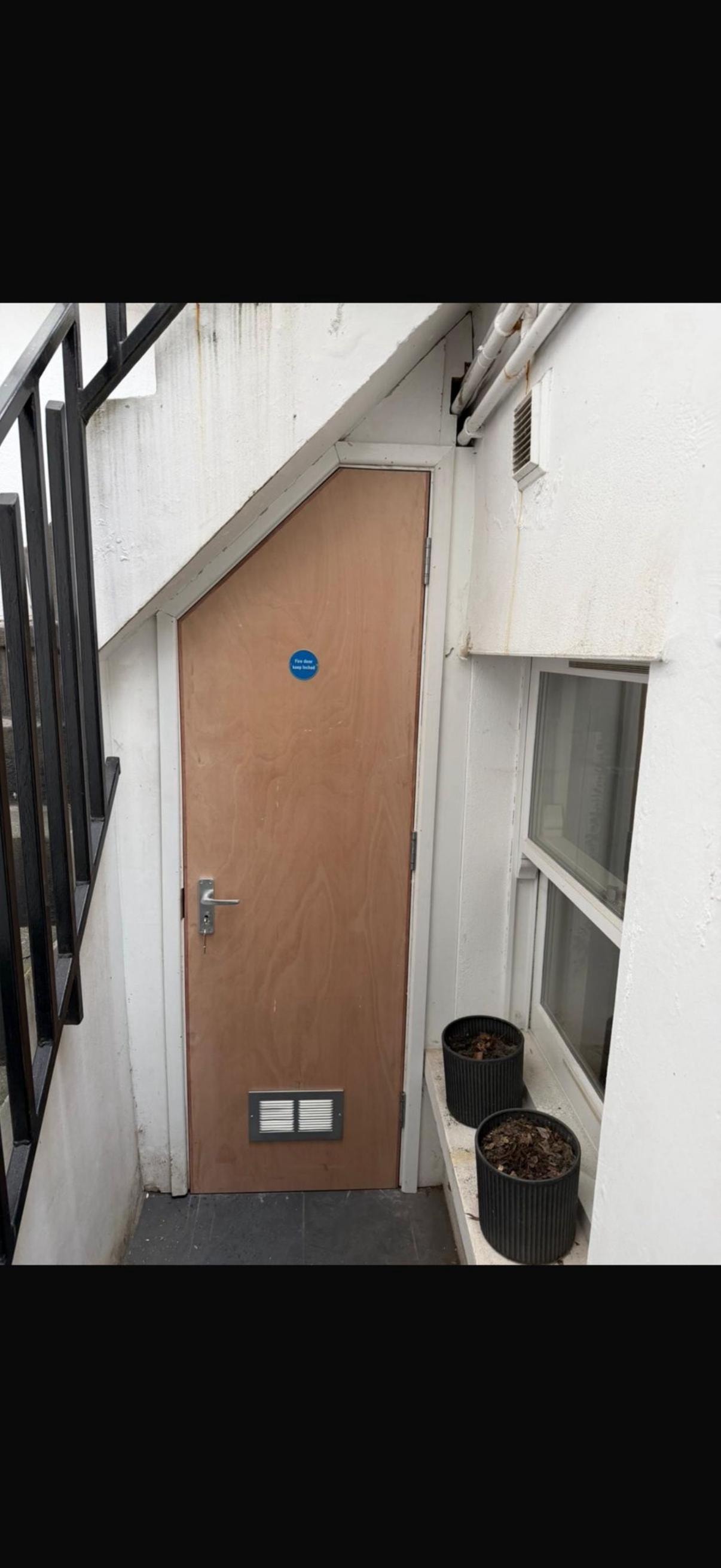 Brown wooden fire door narrow alleyway entrance