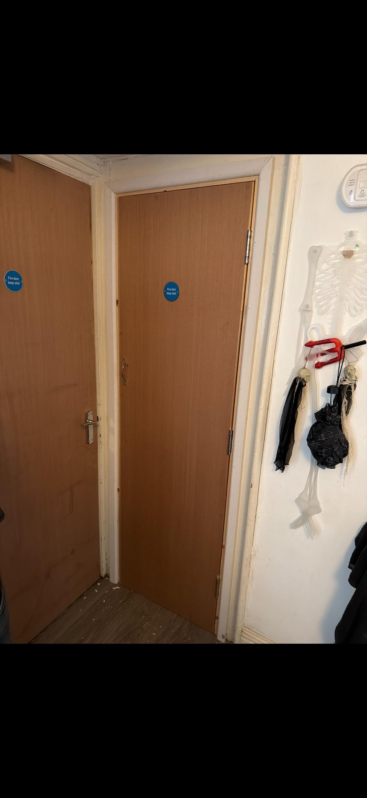 Hallway with brown fire doors and wall hooks