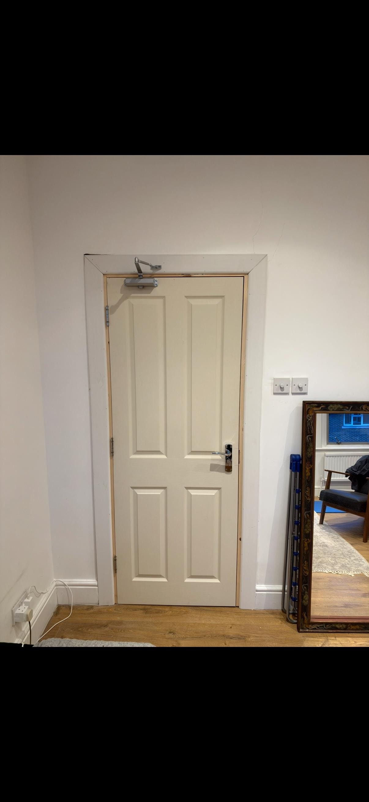 Cream six-panel fire door in communal hallway
