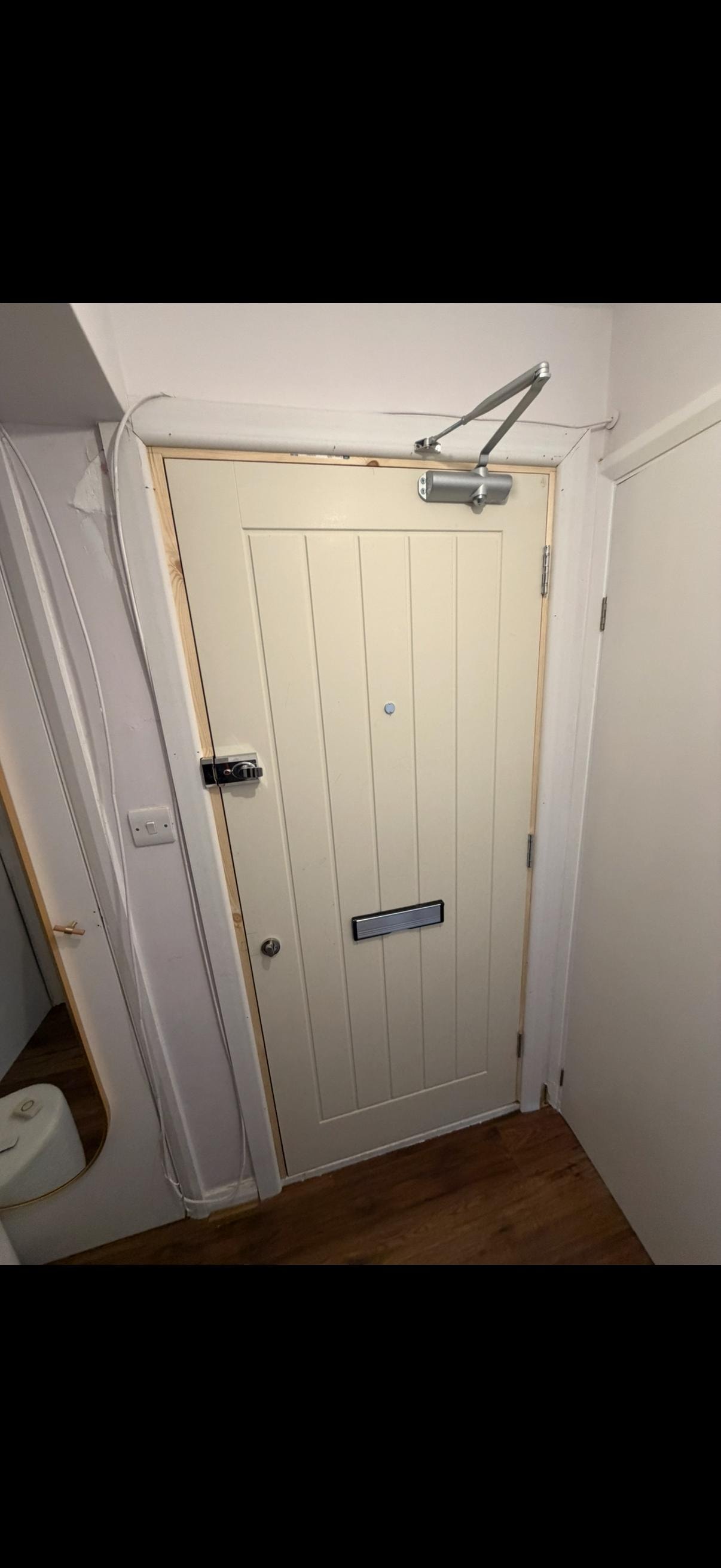 Cream fire door with automatic closer installed