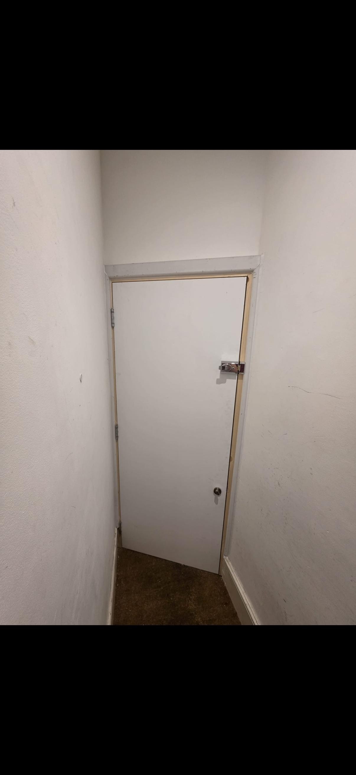 White fire door in narrow hallway