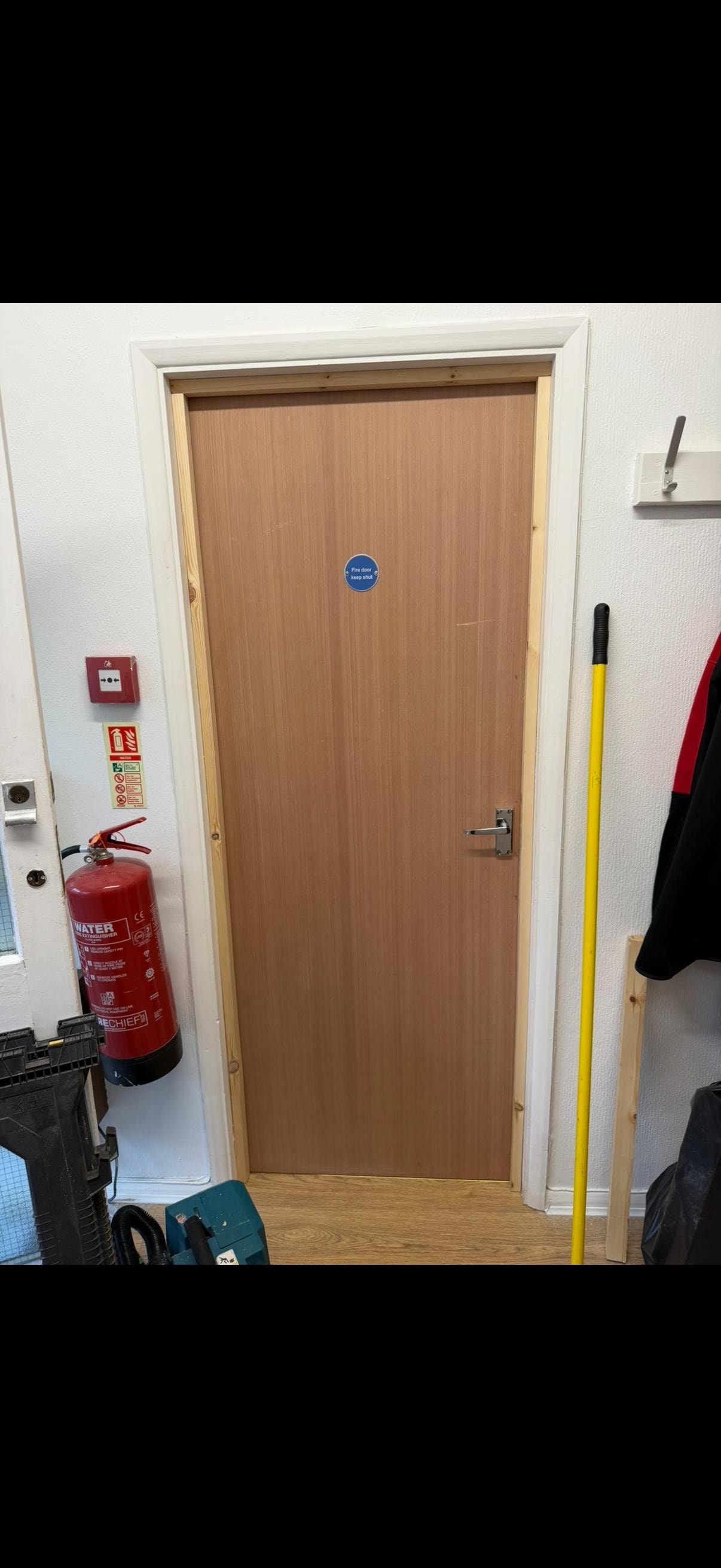 Wooden fire door with fire extinguisher nearby
